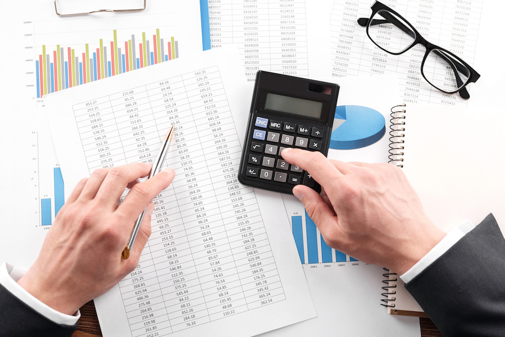 Business valuation process showing financial analysis with calculator and charts in a UAE context