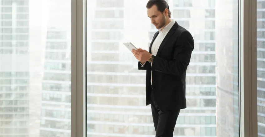 businessman-working-tablet-near-large-window